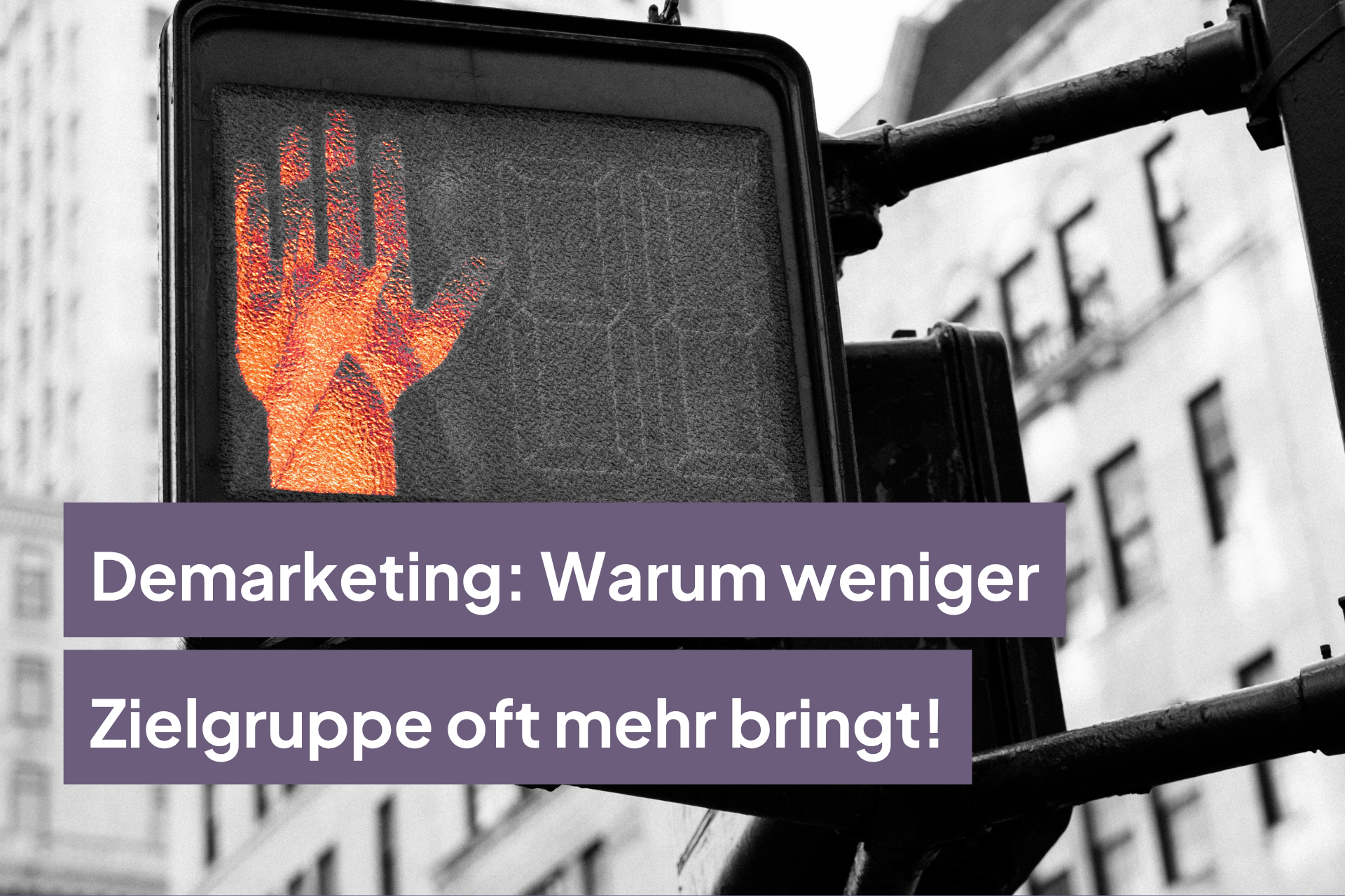 Fußgängerampel mit roter Hand zeigt „Stopp“-Signal in einer Stadtumgebung.